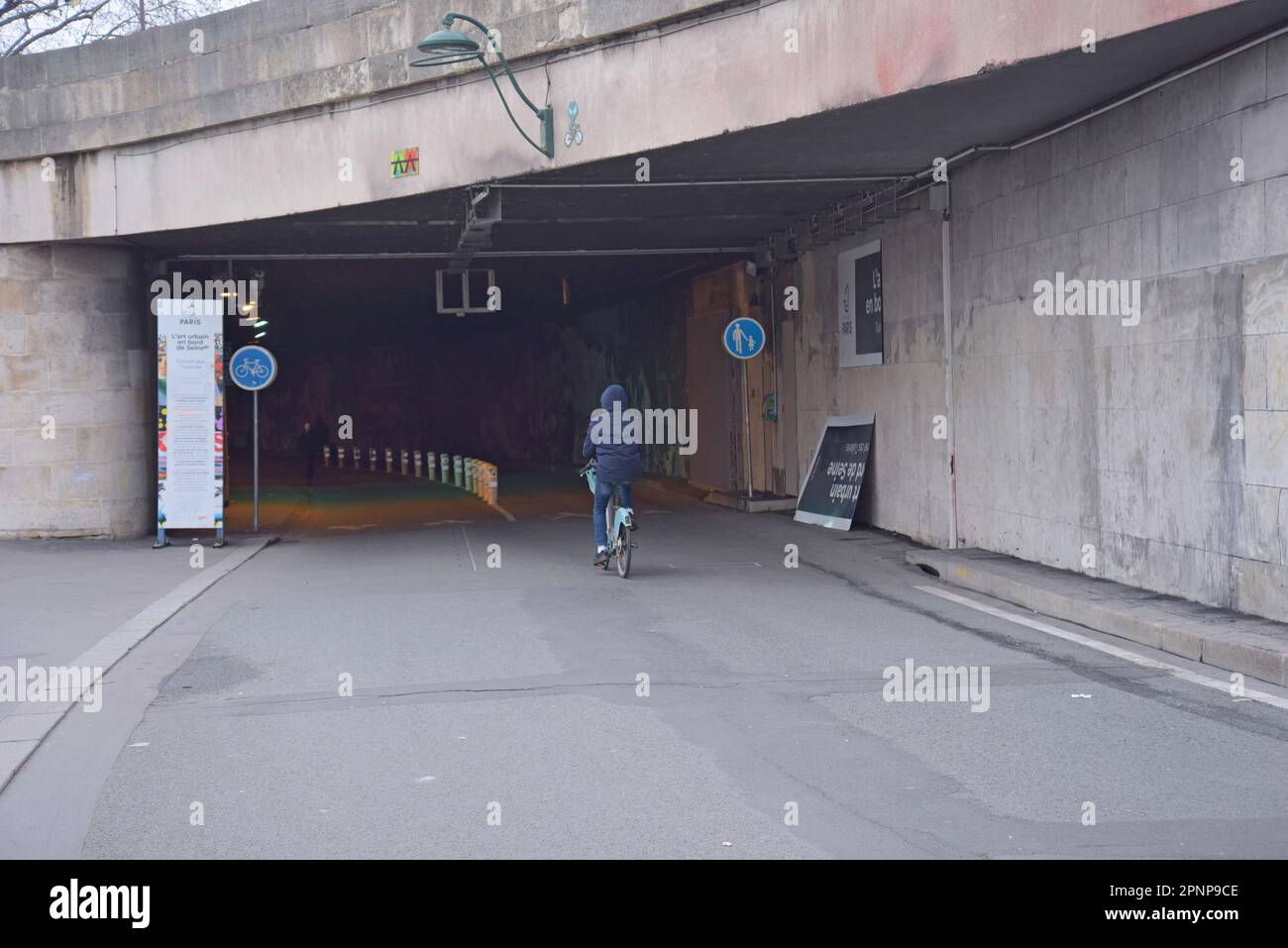 Un cycliste entre dans le tunnel des Tuileries et la route piétonne sous la Seine, un ancien tunnel pour voitures. Paris, France, janvier 2023 Banque D'Images