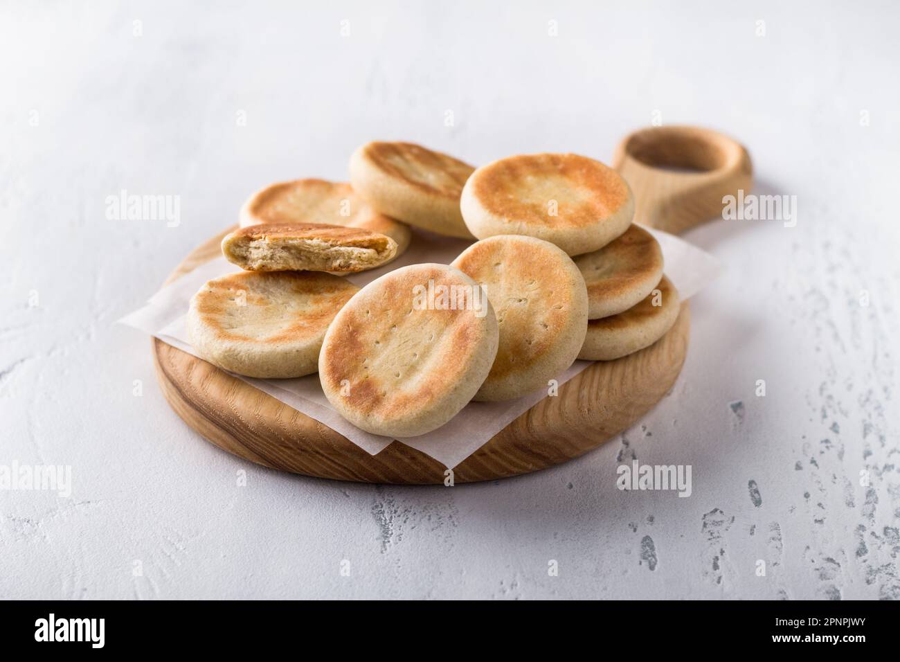 Planche en bois avec de délicieux petits gâteaux faits maison cuits dans une casserole sur un fond clair Banque D'Images