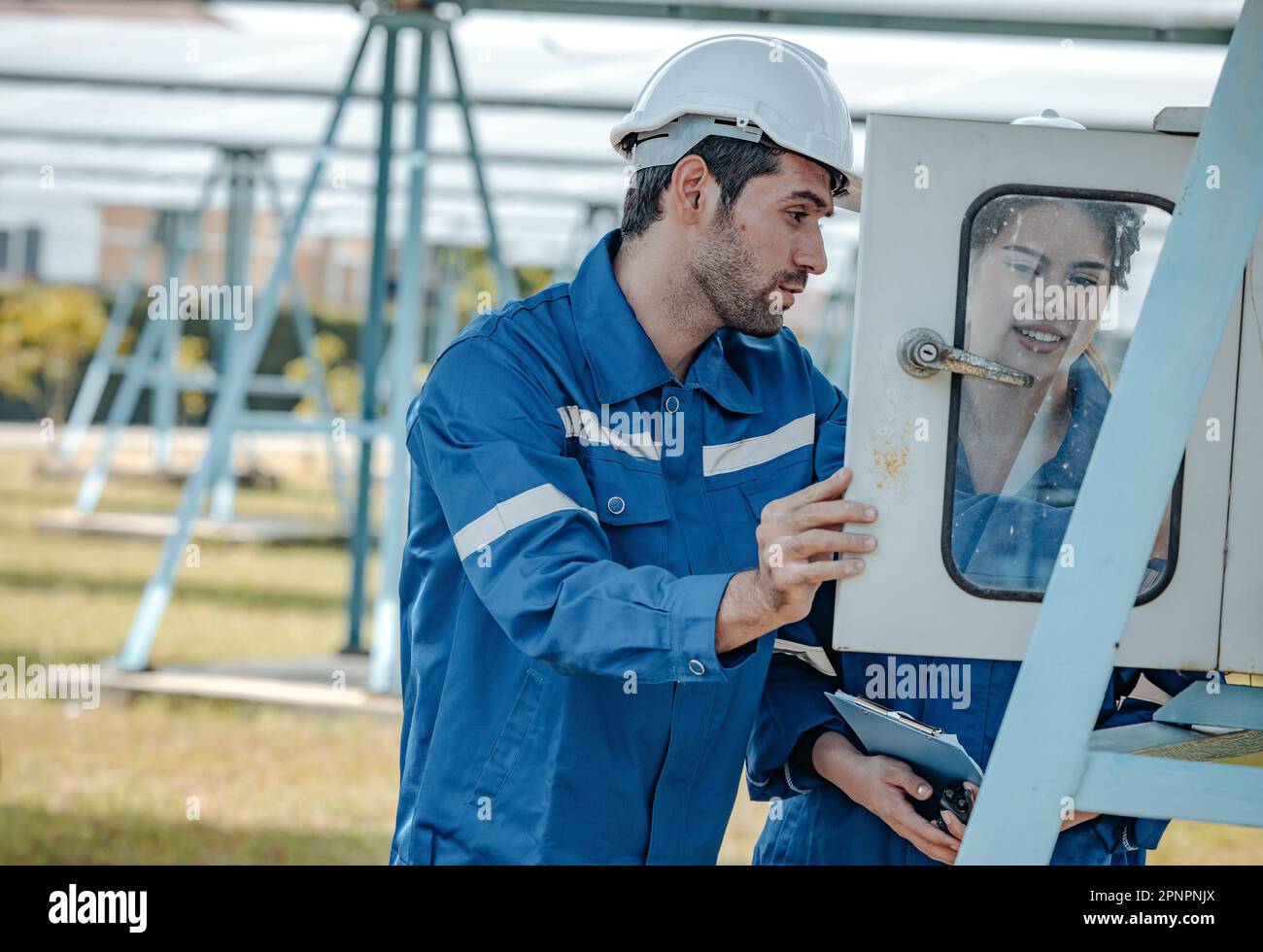 Un installateur et un professionnel de l'électricité solaire inspectent les systèmes électriques pour vérifier le câblage, la polarité, la mise à la terre et la fiabilité des terminaisons. Ci-dessous Banque D'Images