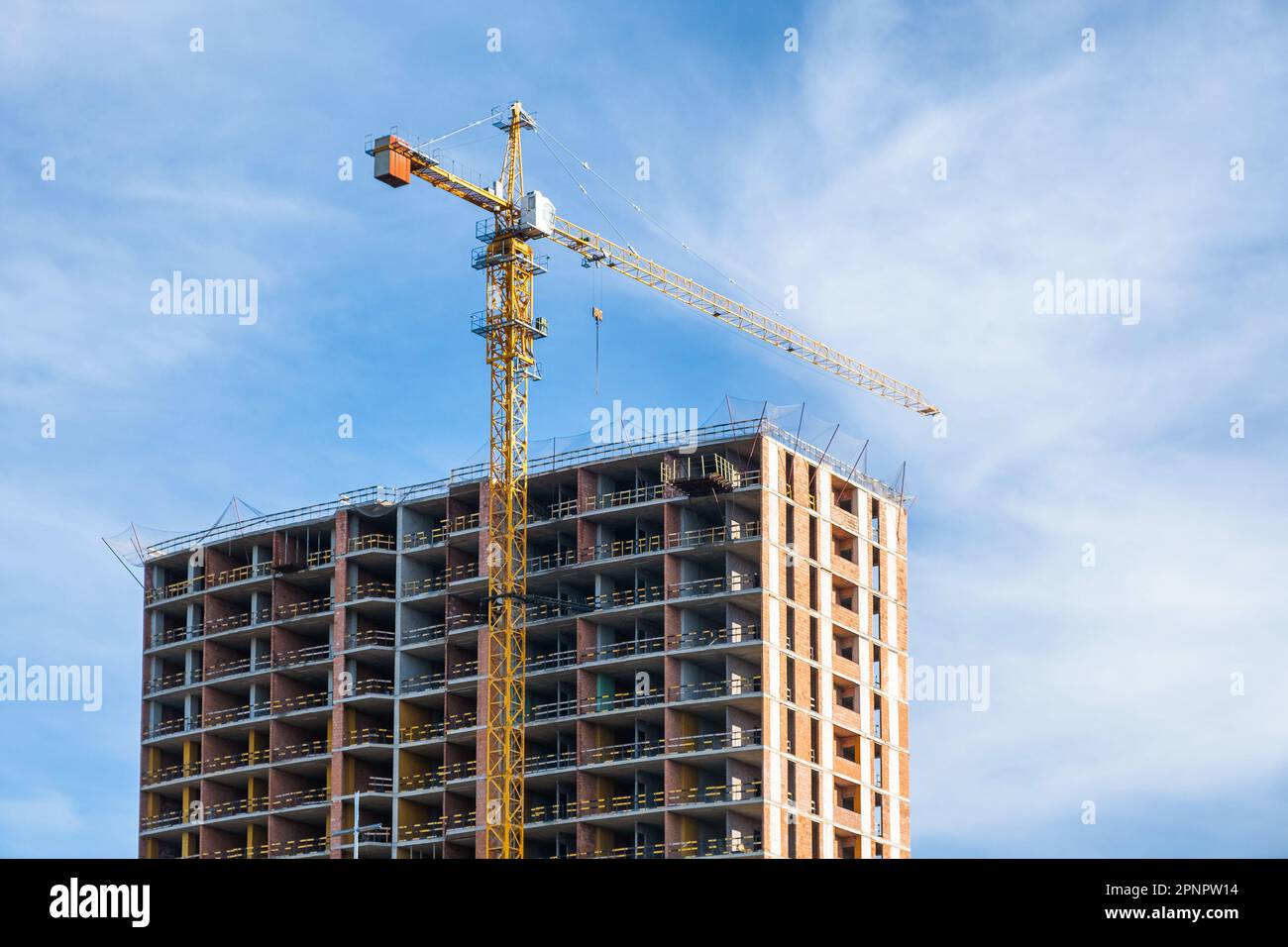 Grue et chantier de construction contre ciel bleu. Industrie de logement de nouveaux bâtiments. Concept industriel Banque D'Images