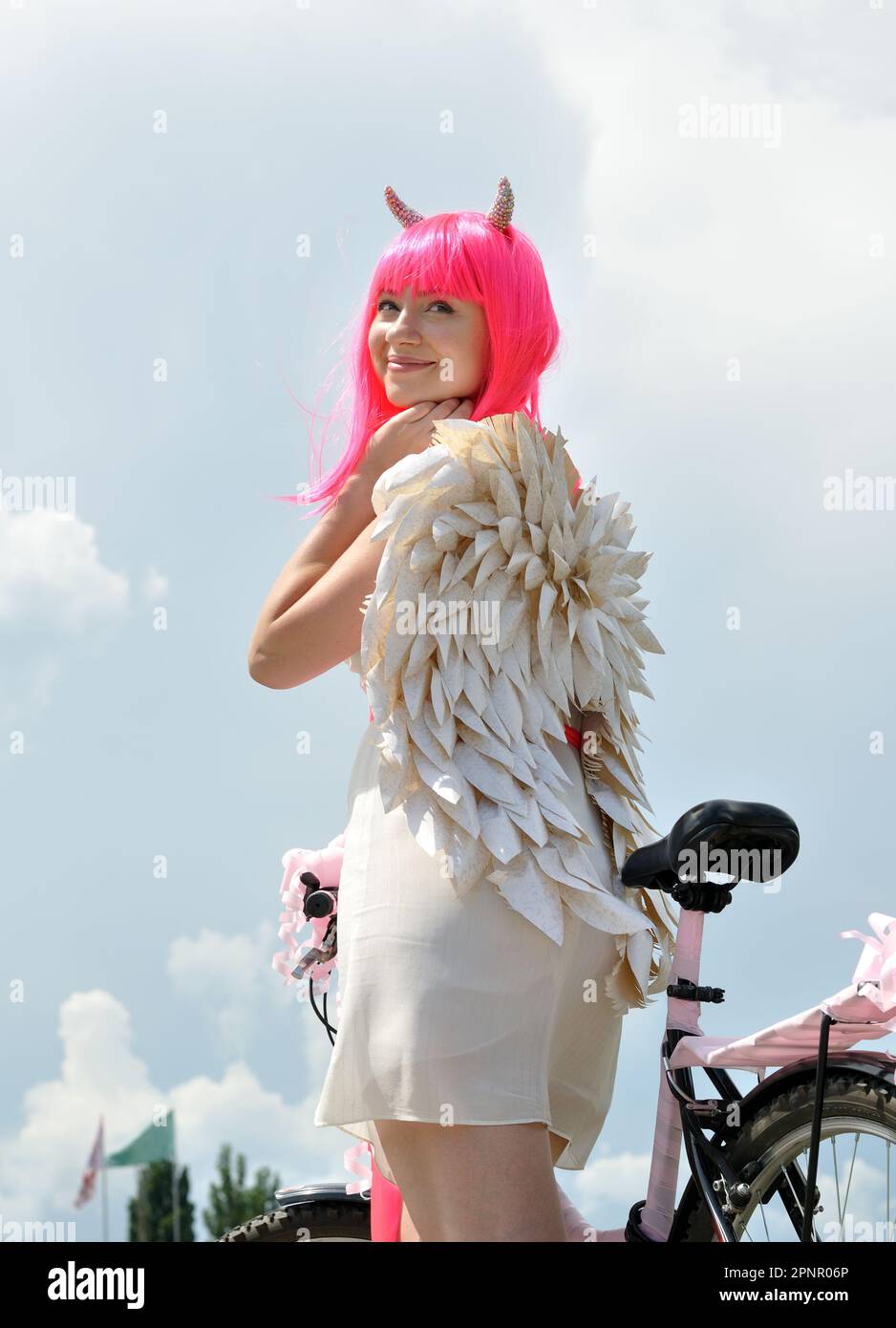 femme attrayante avec vélo en costume de démon voyageant le jour d'été, composition verticale Banque D'Images