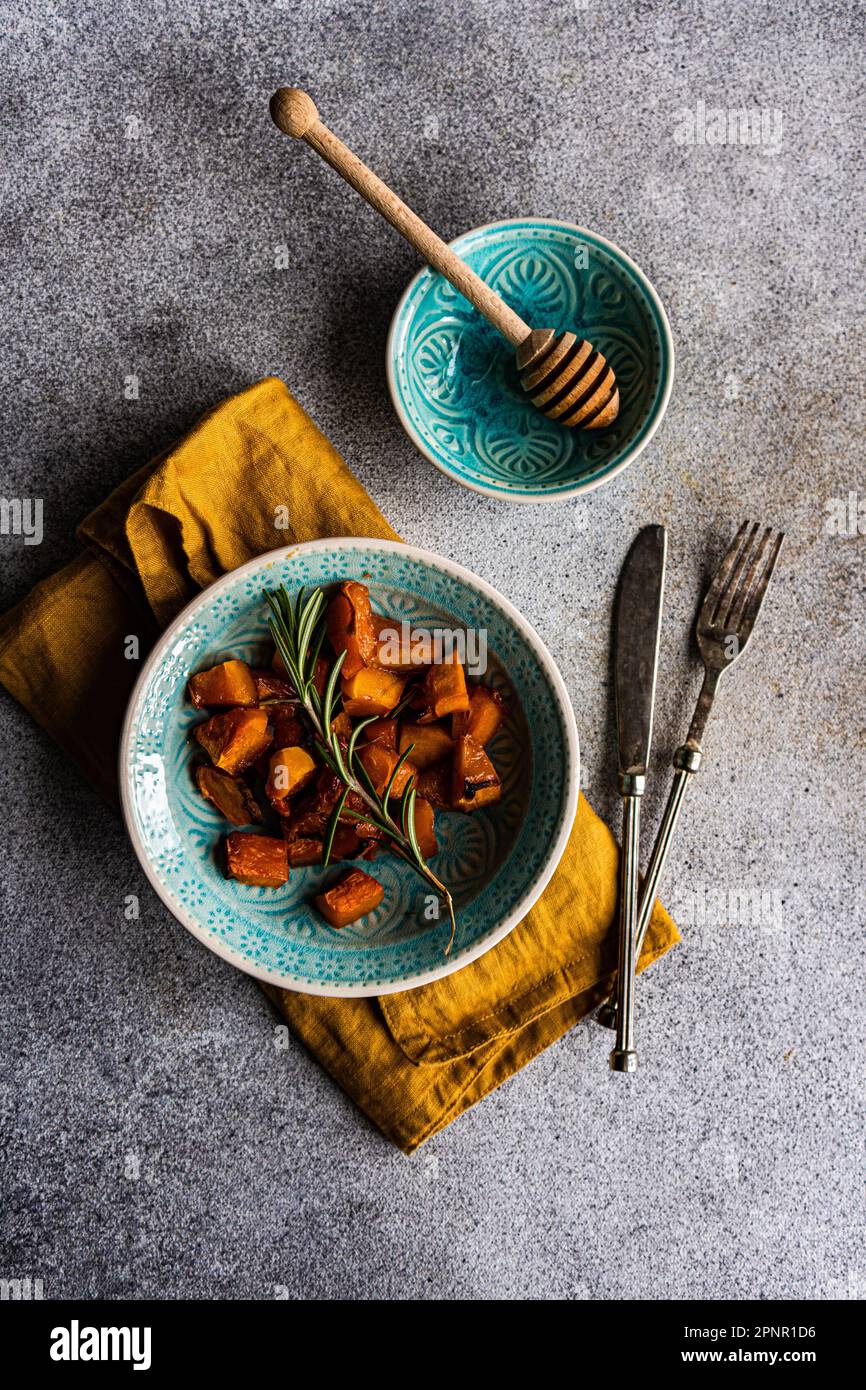 Vue panoramique sur un bol de citrouille rôtie au romarin, au miel et au miel Banque D'Images