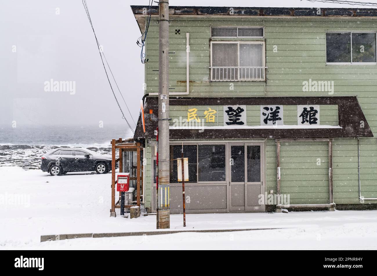 Une entreprise sur la côte de la mer du Japon en hiver dans la préfecture d'Aomori, vue d'un train sur la ligne Gono. Banque D'Images