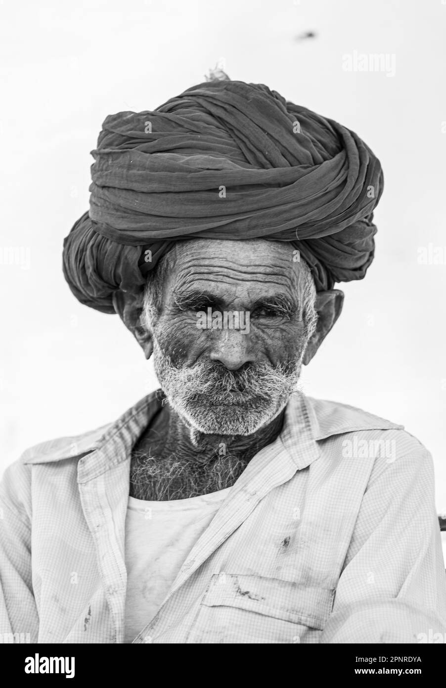 Pushkar, Inde - Oct 2022: Foire de Pushkar, Portrait d'un vieil homme rajasthani avec robe traditionnelle blanche et turban coloré au terrain d'exposition de pushkar Banque D'Images
