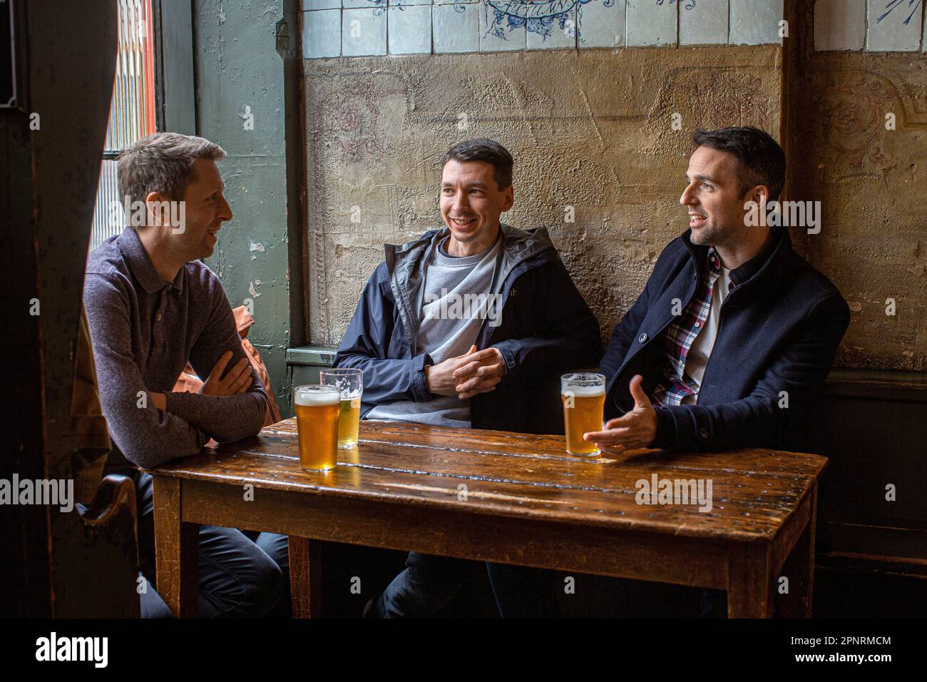Des amis qui boivent de la bière au pub, The Holy Tavern, à Britton Street, Clerkenwell, Londres, Angleterre, Royaume-Uni. Banque D'Images