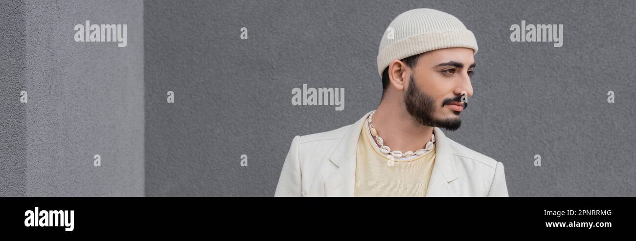 Homme homosexuel élégant en beige chapeau et veste regardant loin dehors, bannière, image de stock Banque D'Images
