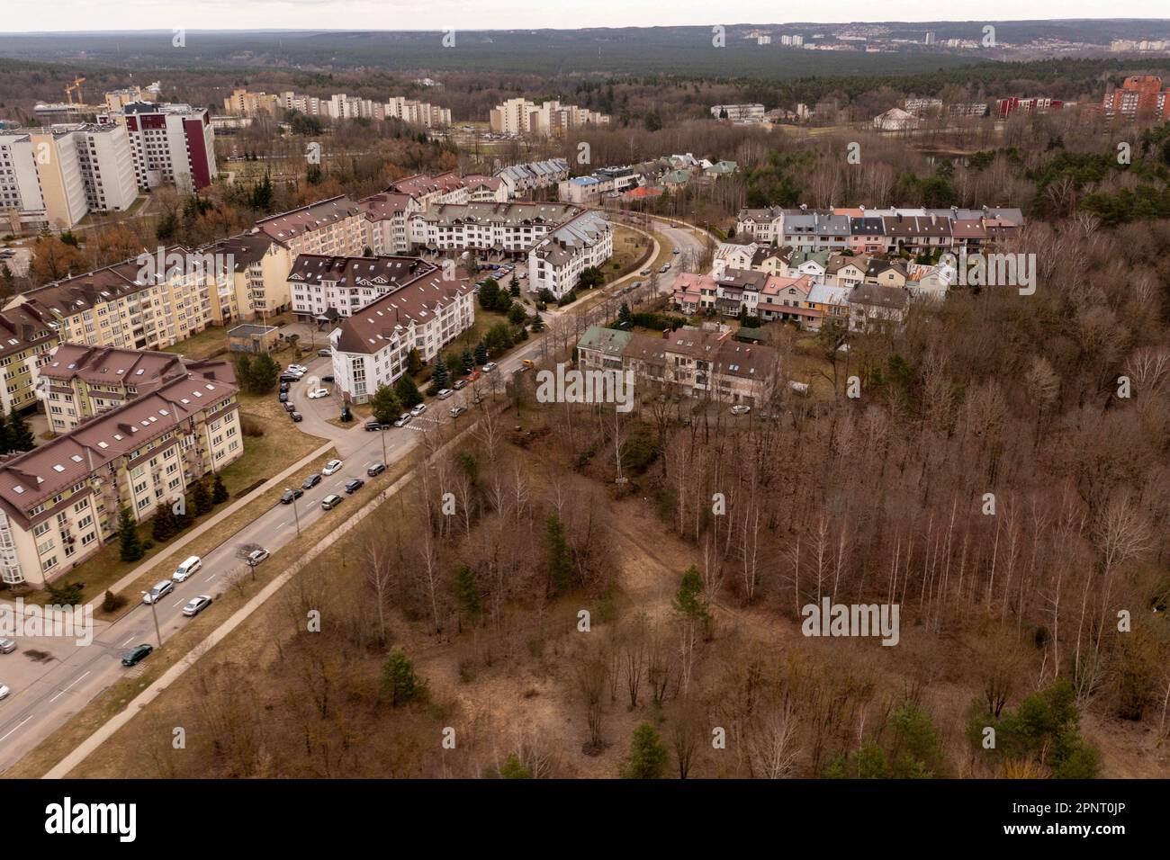 Photographie par drone d'une zone résidentielle entourée de forêt au printemps, jour nuageux Banque D'Images