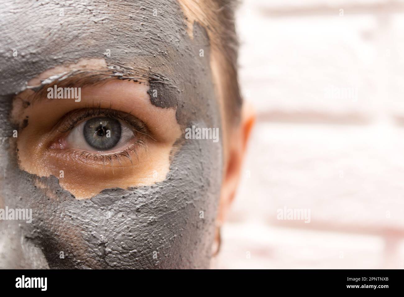 Vue à mi-hauteur du visage d'une femme avec masque cosmétique noir Banque D'Images