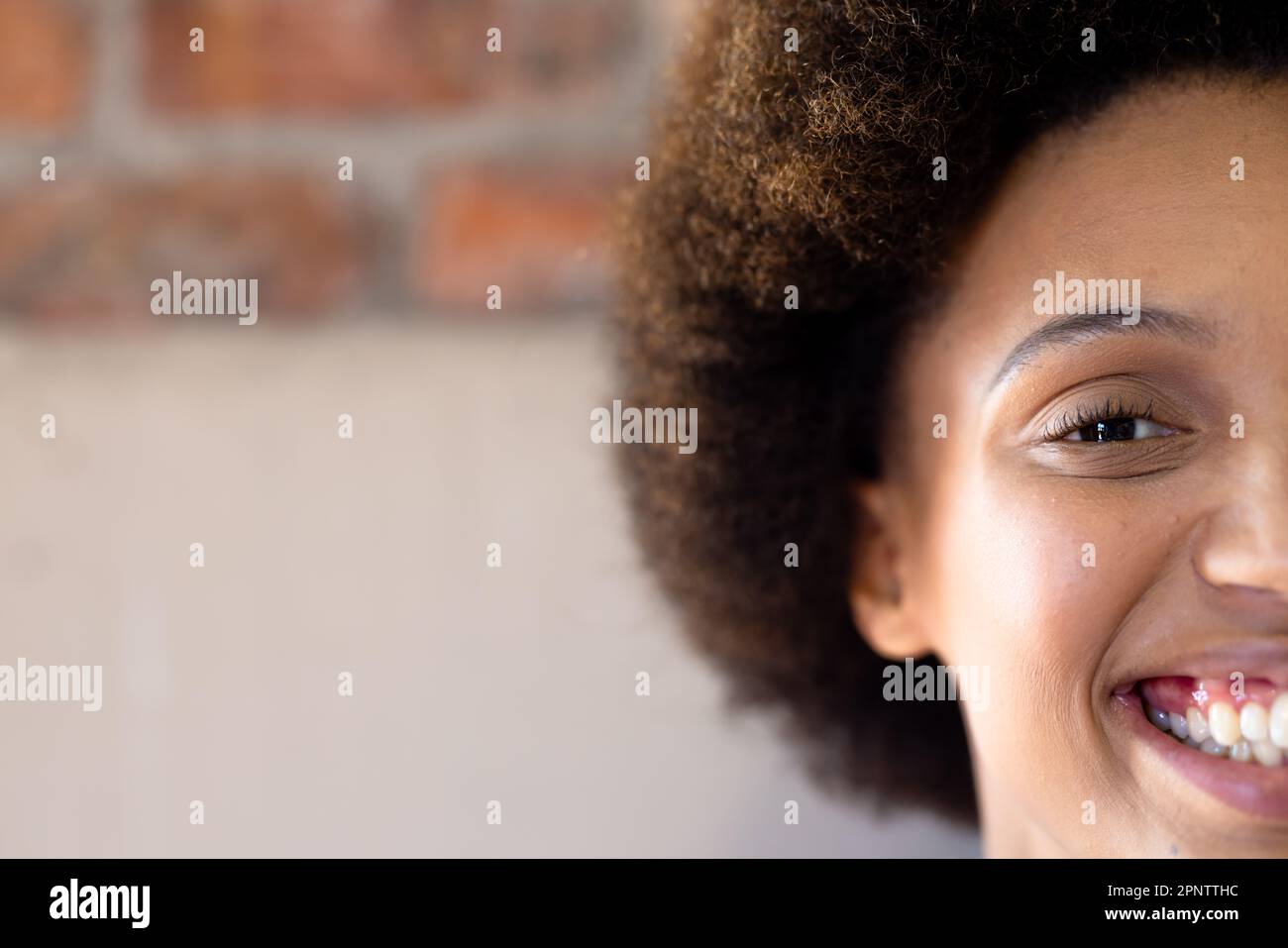 Portrait à moitié de visage gros plan de heureux biracial décontracté femme d'affaires souriante, espace de copie Banque D'Images