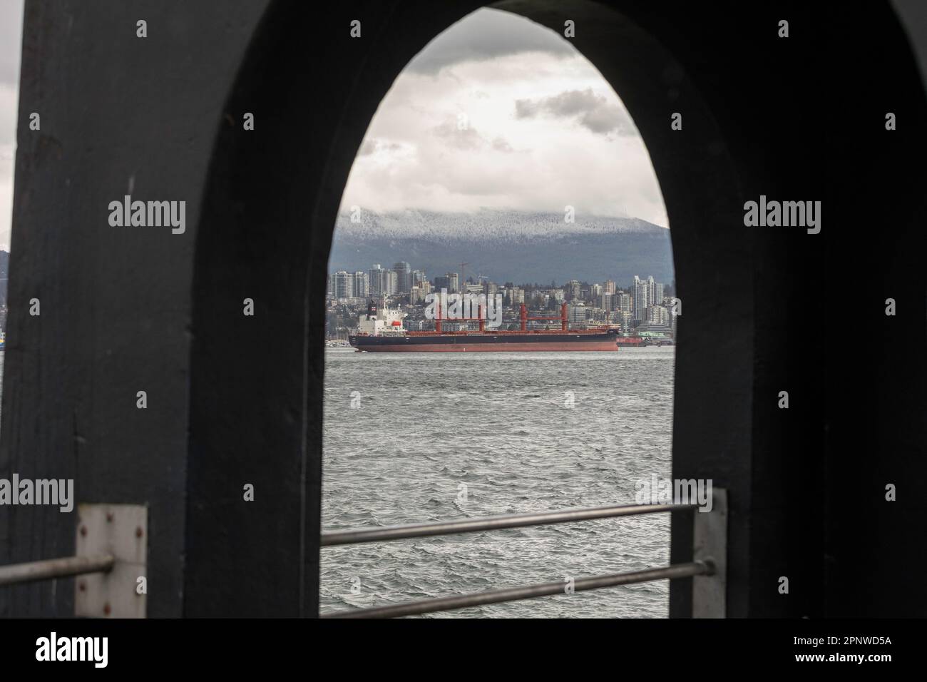 On voit un cargo, devant un pluvieux Vancouver-Nord, à partir du sentier côtier du parc Stanley, à Vancouver, en Colombie-Britannique, au Canada Banque D'Images