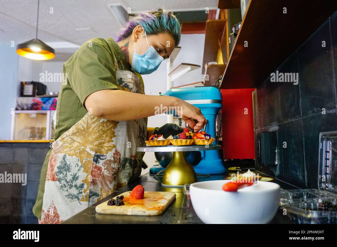 Alejandra Saldaña Rodríguez décore des tartes avec des baies dans son café à Oaxaca de Juárez, Mexique sur 23 juin 2022. Saldaña explique que son magasin honore ses grands-mères, qui souffraient de diabète : « C’est pourquoi, maintenant, je veux faire des desserts [sans gluten, sans sucre et sans produits laitiers] que tout le monde peut manger. » (ENA Aguilar Peláez/Global Press Journal) Banque D'Images