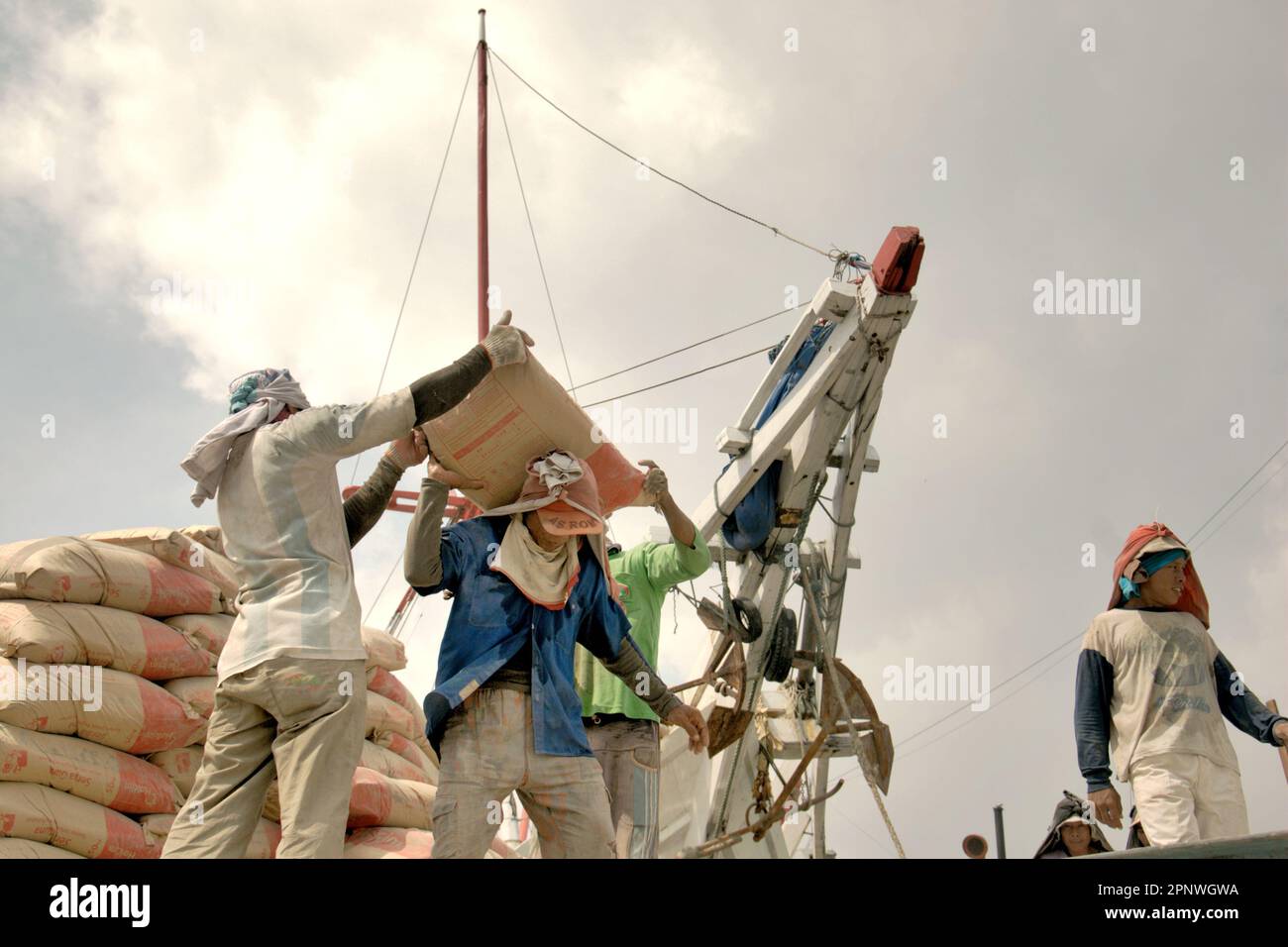 Les travailleurs transportent des sacs de ciment d'un camion sur un navire phinisi au port traditionnel de Sunda Kelapa à Penjaringan, dans le nord de Jakarta, à Jakarta, en Indonésie. Le changement climatique exposera de plus en plus les travailleurs extérieurs au stress thermique et à la réduction de la capacité de main-d'œuvre, selon le rapport de 2023 publié par le Groupe d'experts intergouvernemental sur l'évolution du climat (GIEC), intitulé "changement climatique 2022: Impacts, adaptation et vulnérabilité". Selon le rapport, les solutions recommandées pour la gestion de l'exposition à la chaleur chez les travailleurs en plein air comprennent une protection de base améliorée (y compris l'ombre et les pauses prévues), ... Banque D'Images