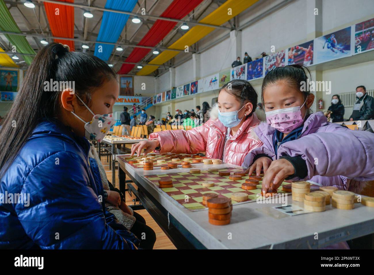 Sarantsetseg Enkhtuvshin, 7, à droite, joue avec Buyanbayan Enkhtuvshin, 9, à gauche, à Erdenebulgan, province d'Arkhangai, Mongolie sur 19 février 2022. Le Championnat Arkhangai 100 Shot Checkers Championship pour les enfants âgés de 5 à 16 ans a eu lieu après la levée des restrictions COVID-19. (Odonchimeg Batsukh/Global Press Journal) Banque D'Images