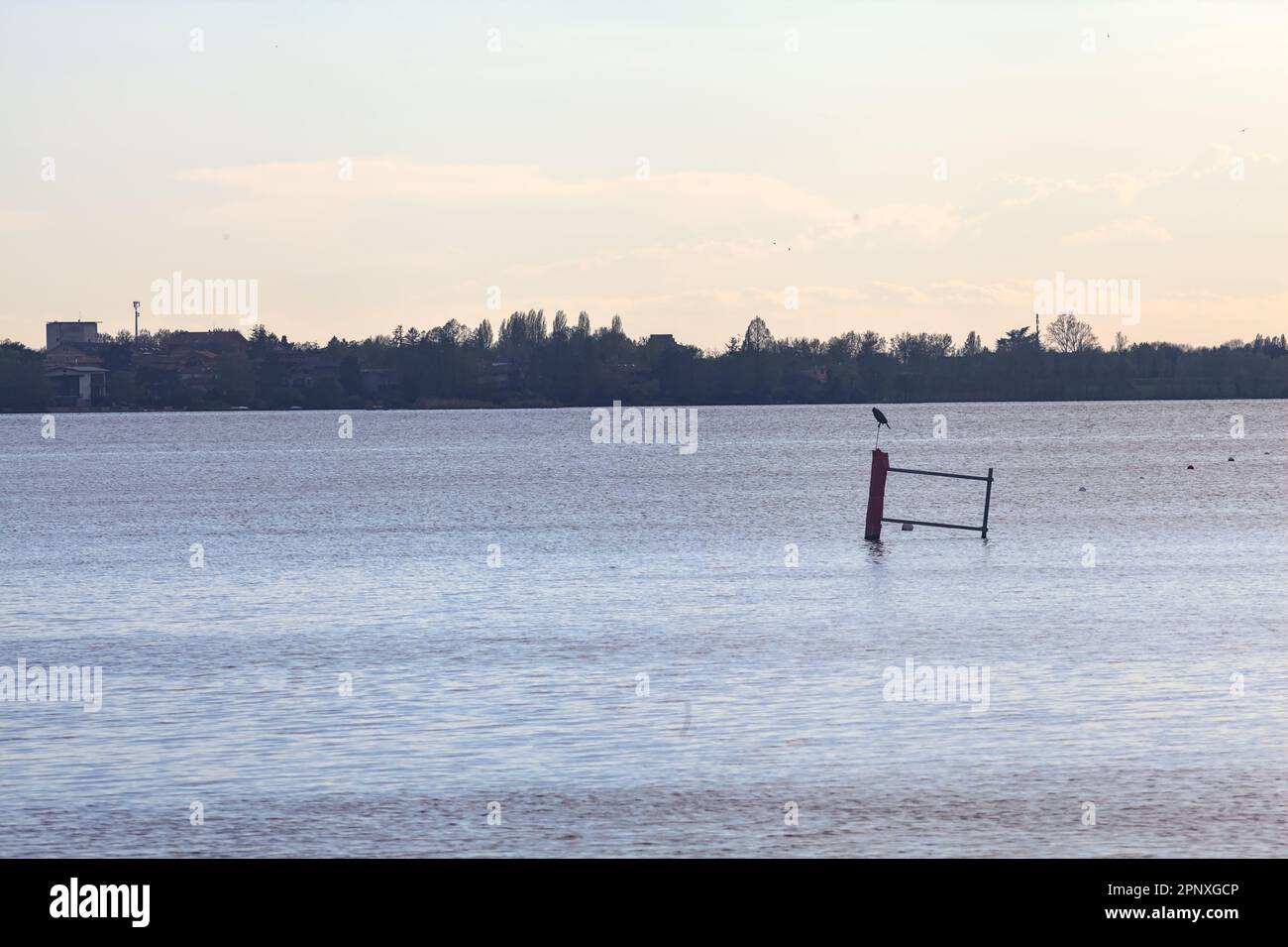 Poteau d'amarrage au milieu d'un lac au coucher du soleil Banque D'Images