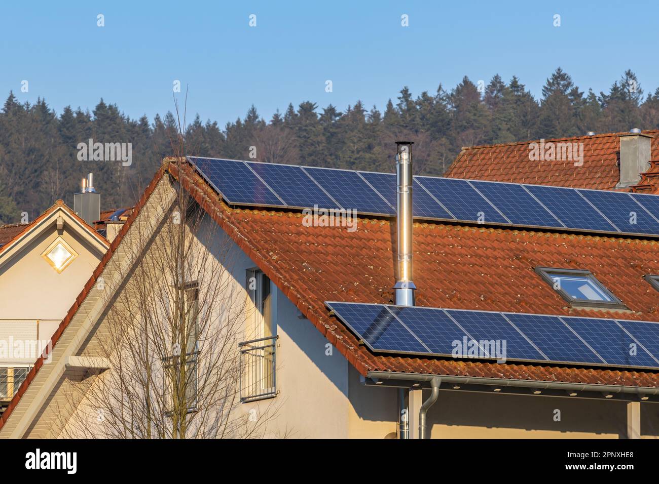 maison individuelle avec panneaux solaires sur le toit et cheminée en acier inoxydable Banque D'Images