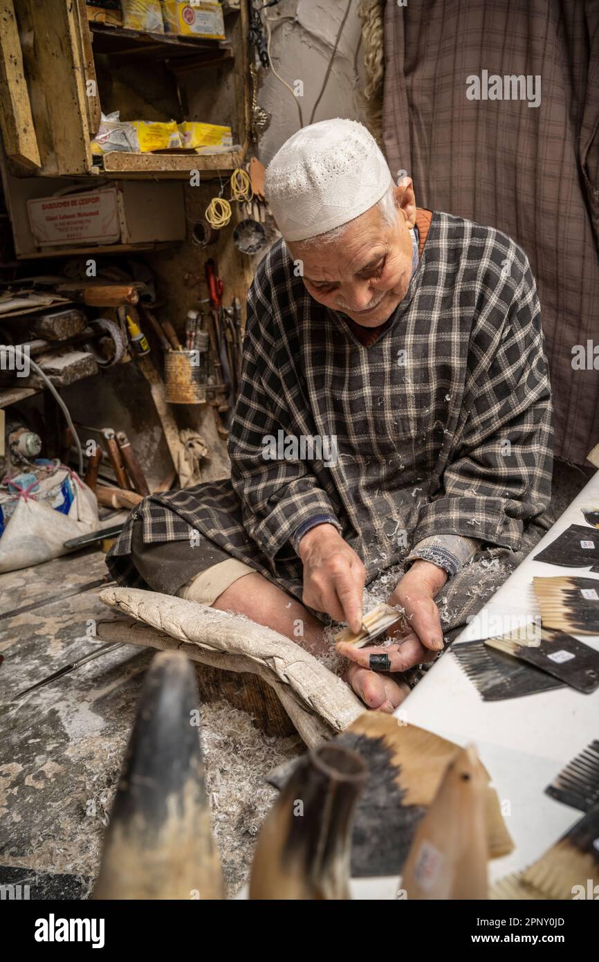 Artisan sculptant à la main une corne de vache pour faire des peignes faits à la main. Banque D'Images