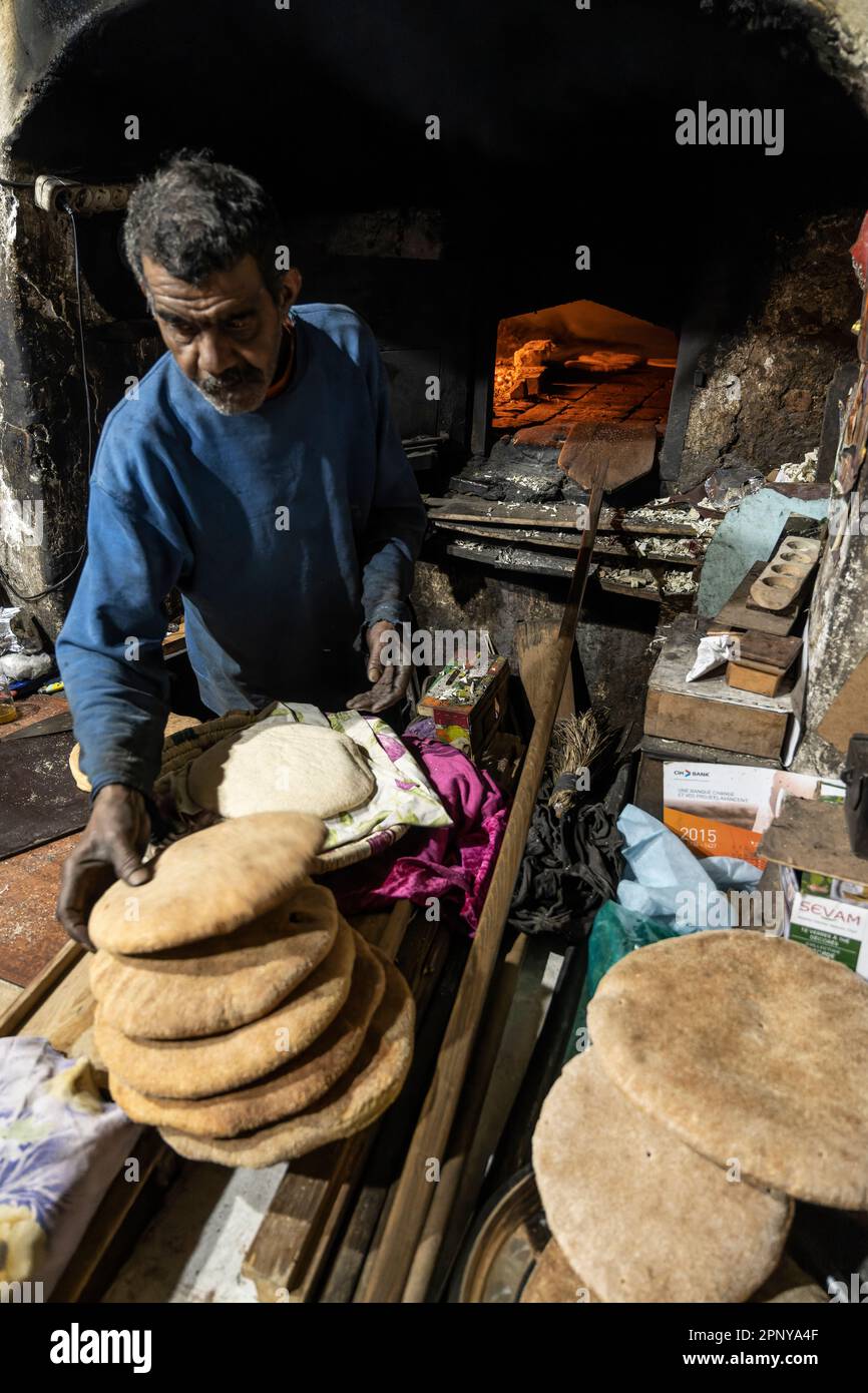 Baker fait du pain dans un four traditionnel au feu de bois dans la médina de Marrakech. Banque D'Images