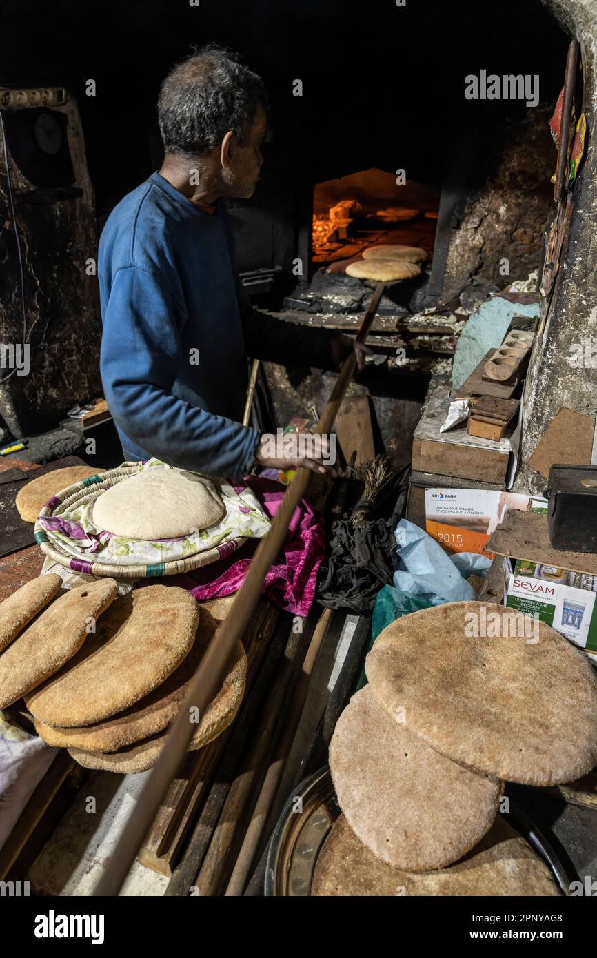 Baker fait du pain dans un four traditionnel au feu de bois dans la médina de Marrakech. Banque D'Images