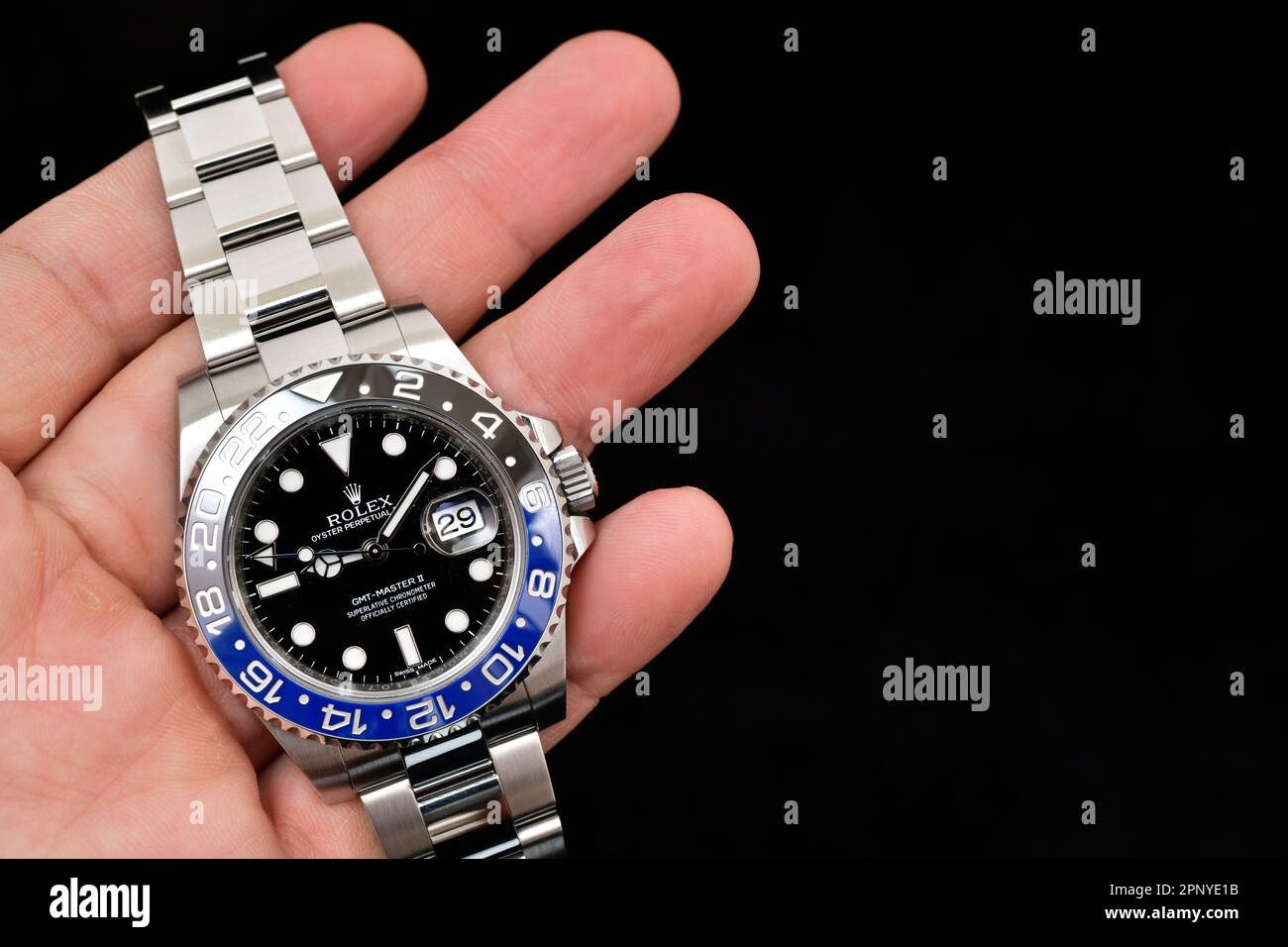 Bangkok Thaïlande- Fév 20,2022 :main tenant Rolex GMT-Master II 'Batman'40mm avec cadre bleu-noir acier céramique montre pour hommes sur fond noir Banque D'Images