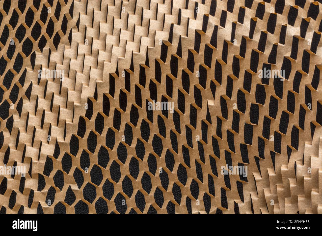 Gros plan de papier de remplissage en nid d'abeille déchiqueté utilisé dans les processus de manutention des matériaux pour l'expédition de marchandises ou de produits délicats. Banque D'Images