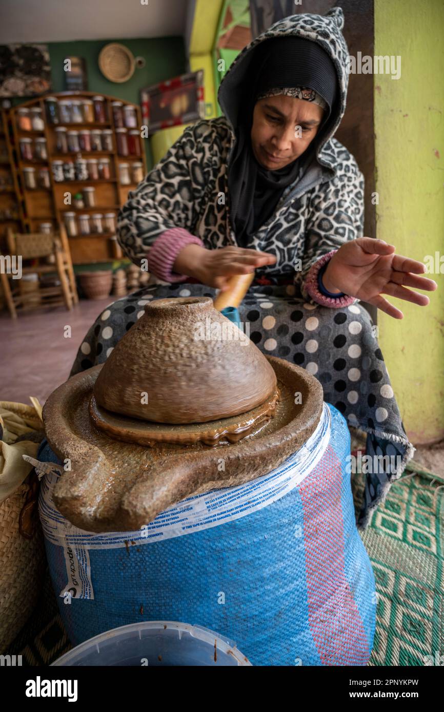 Berber lady produisant de la pâte d'argan avec un moulin à pierre manuel. Banque D'Images