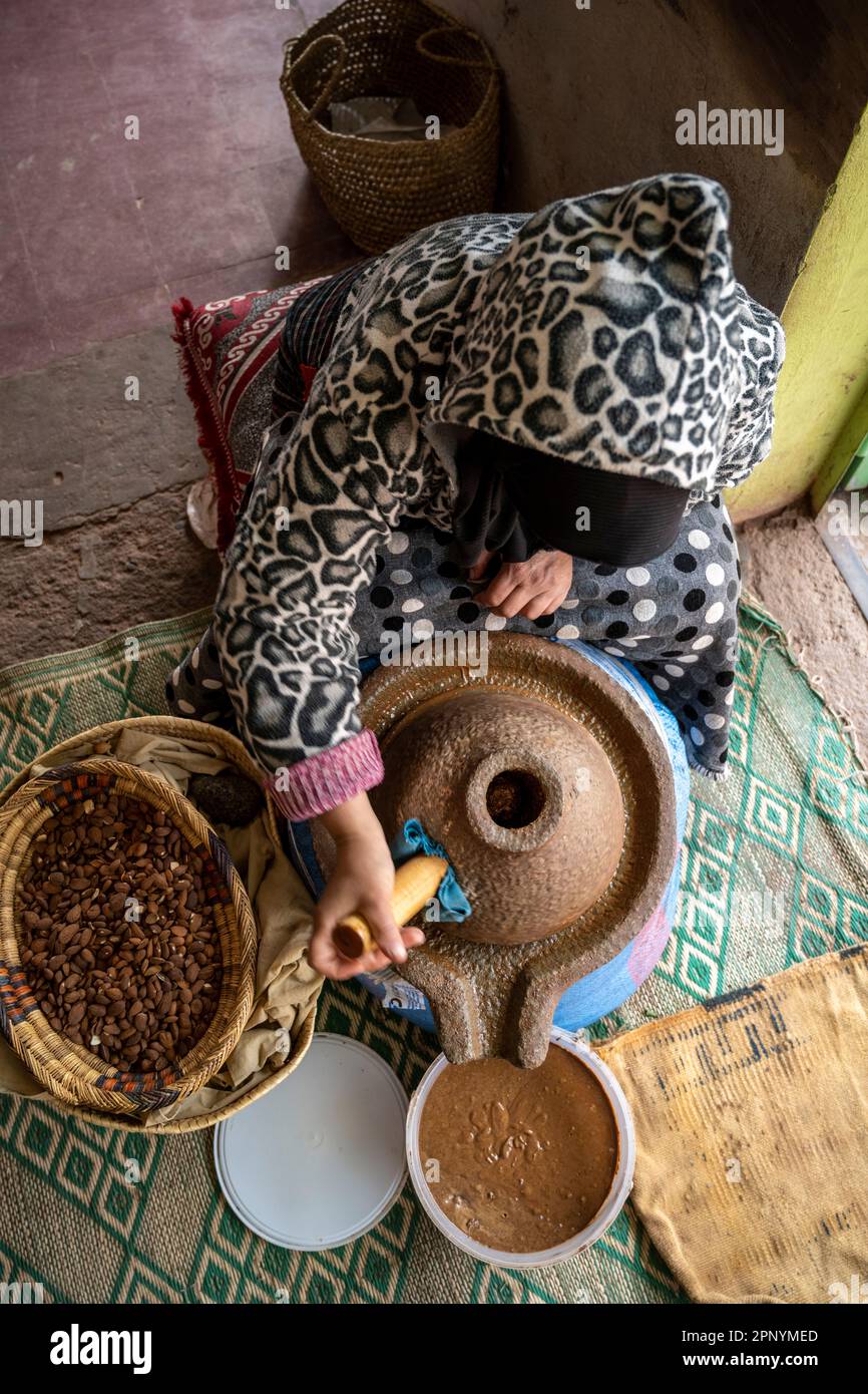 Berber lady produisant de la pâte d'argan avec un moulin à pierre manuel. Banque D'Images