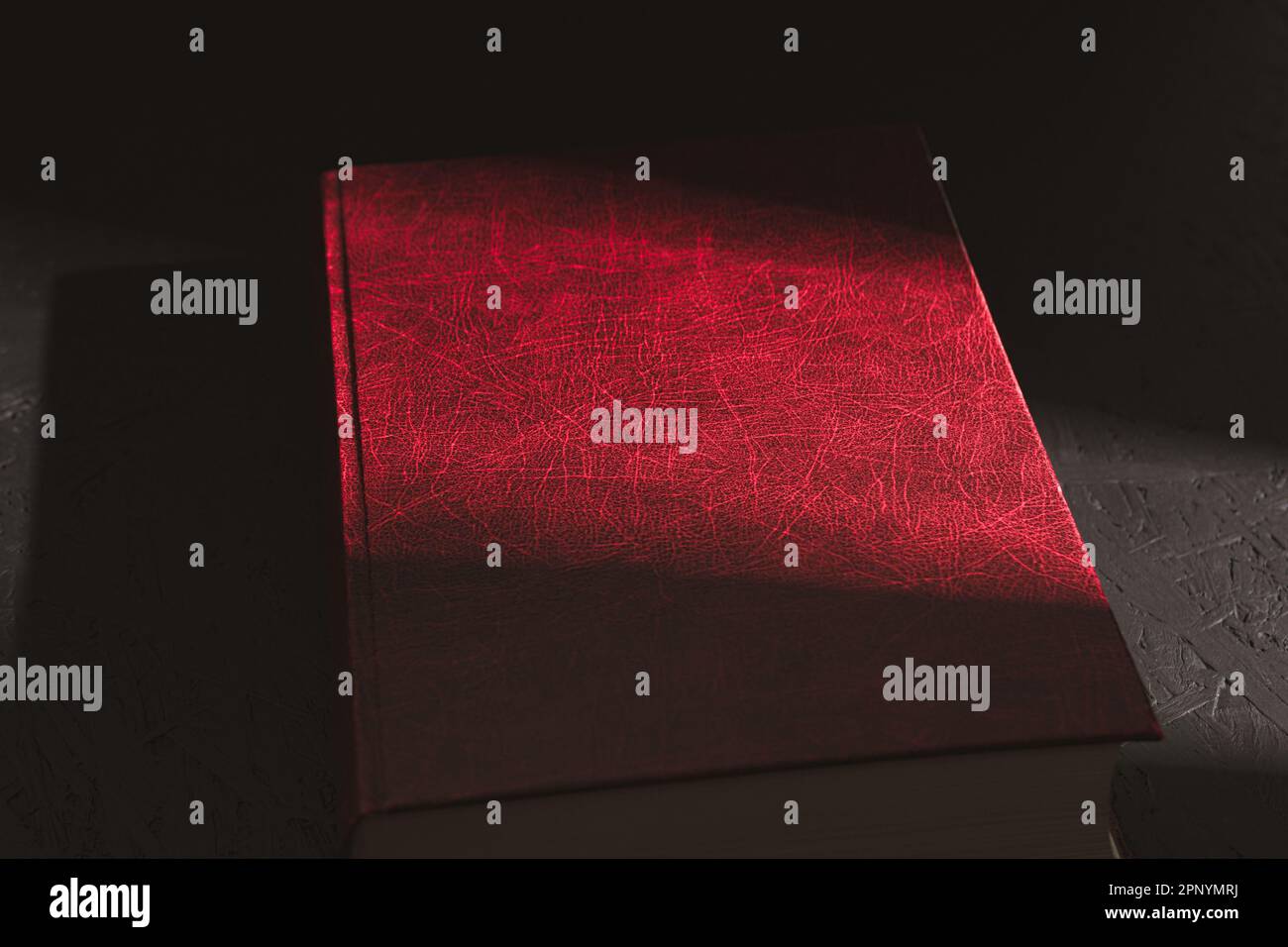 Un vieux livre rouge, Un rayon de soleil dur tombe sur un vieux livre rouge. Sunbeam sur le livre. Gros plan Banque D'Images