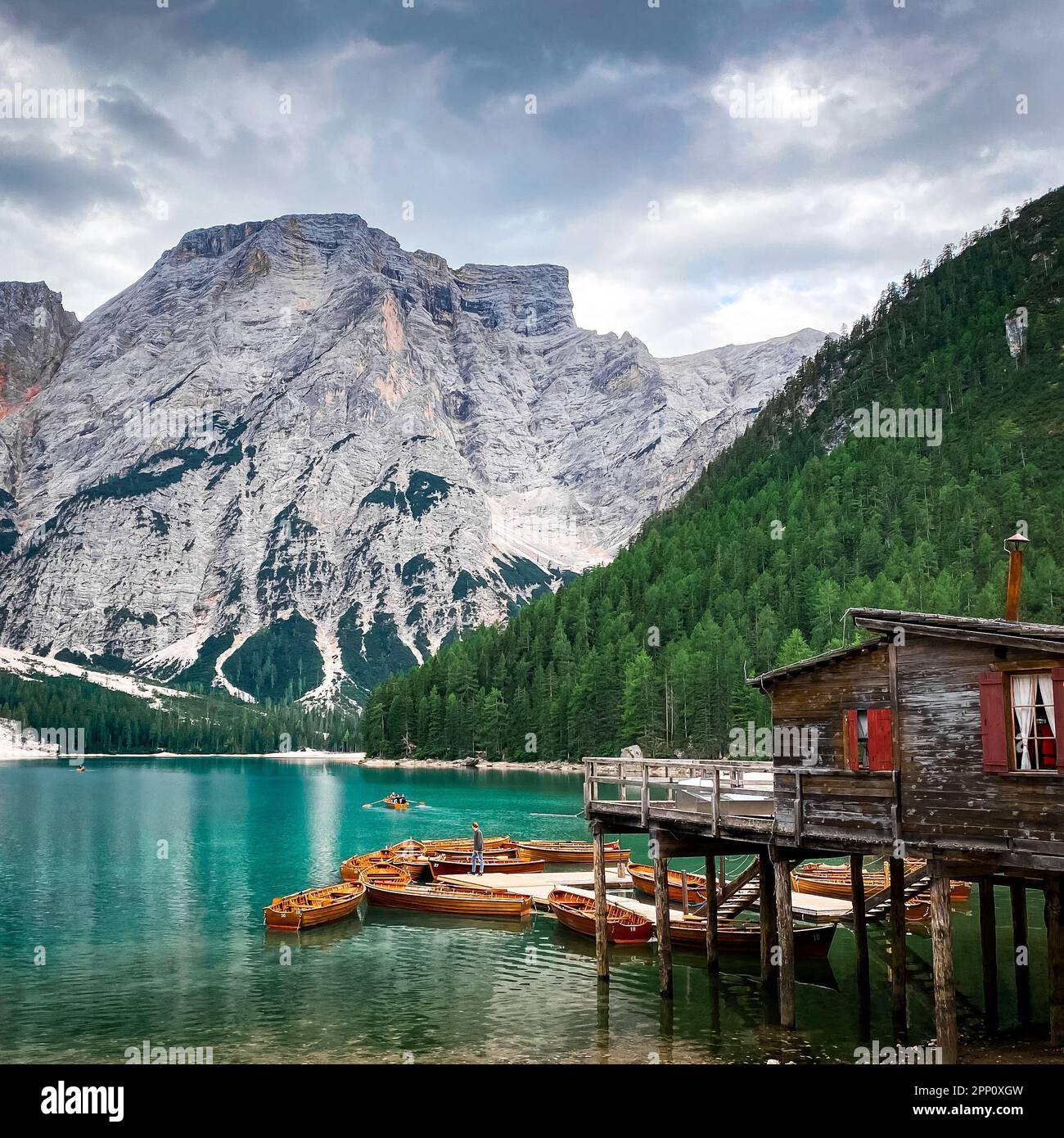 Un paysage côtier pittoresque avec plusieurs petits bateaux en bois amarrés sur la rive avec une montagne majestueuse en arrière-plan Banque D'Images