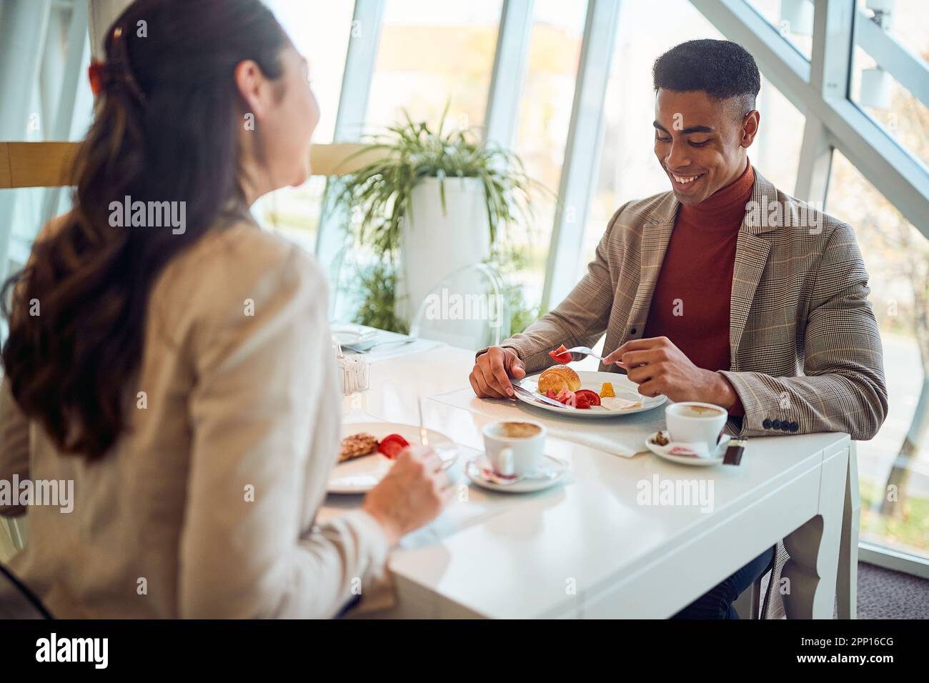 Les jeunes collègues mangent dans une atmosphère détendue dans le restaurant de l'hôtel lors d'un voyage d'affaires. Entreprise, personnes, entreprise Banque D'Images