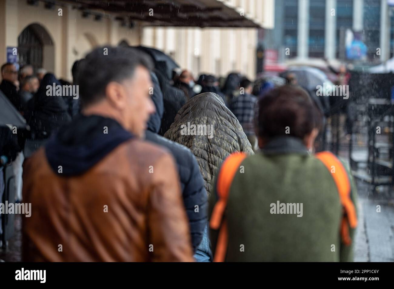 Pendant la pluie torrentielle d'Istanbul, parmi les passagers marchant sur le quai des lignes de Kadikoy, on a vu qu'un homme couvrait sa tête avec son manteau et qu'il était protégé de la pluie. Banque D'Images