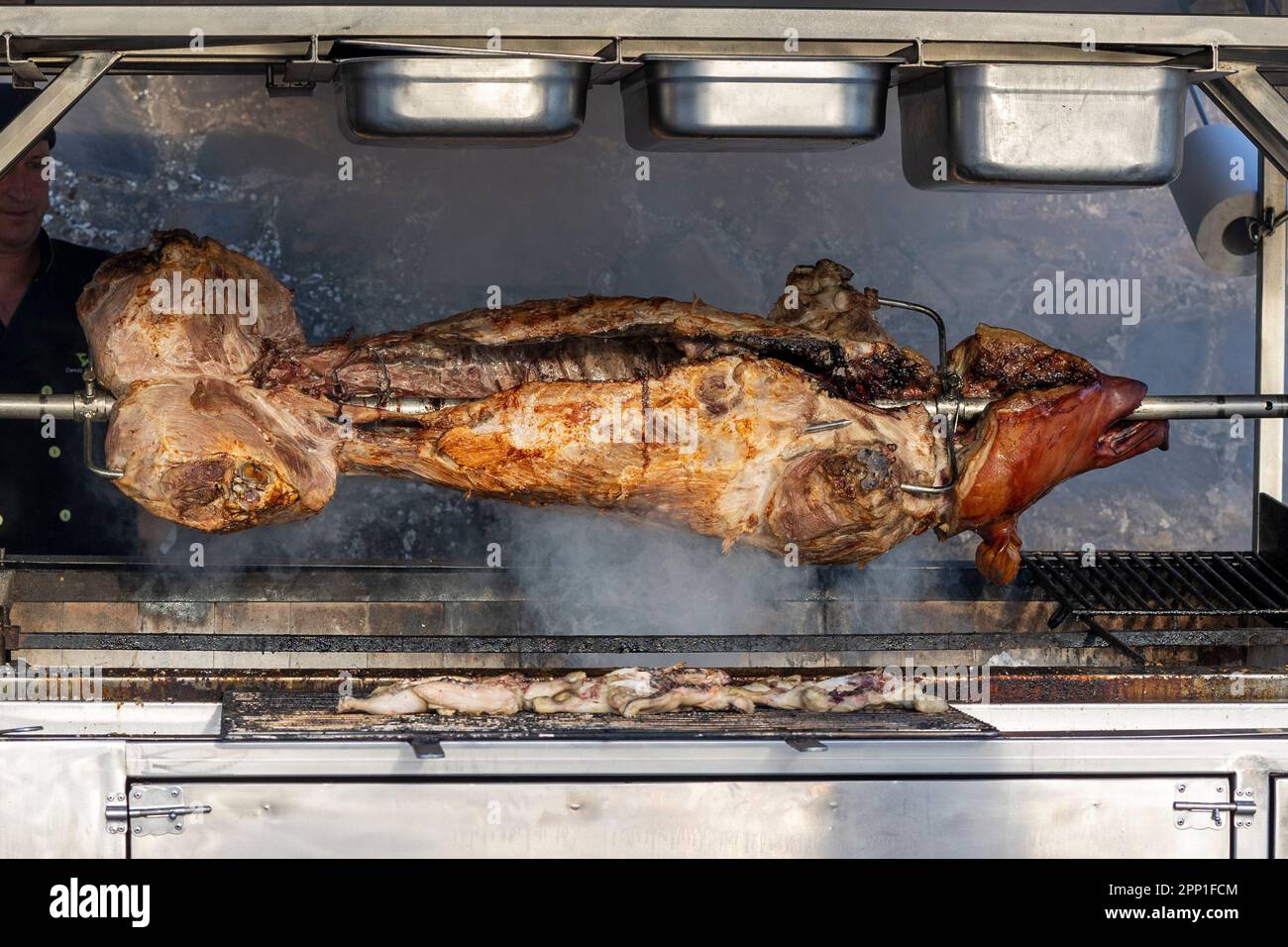 Vue rapprochée d'un cochon rôti sur un barbecue rotatif, broche sur un grill  au charbon de bois Photo Stock - Alamy