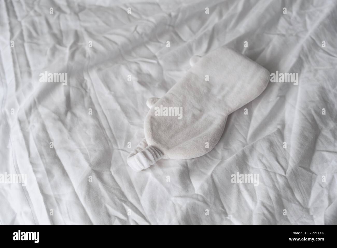 Masque de sommeil reposant sur une literie blanche. Concept d'aou d'insomnie. Banque D'Images