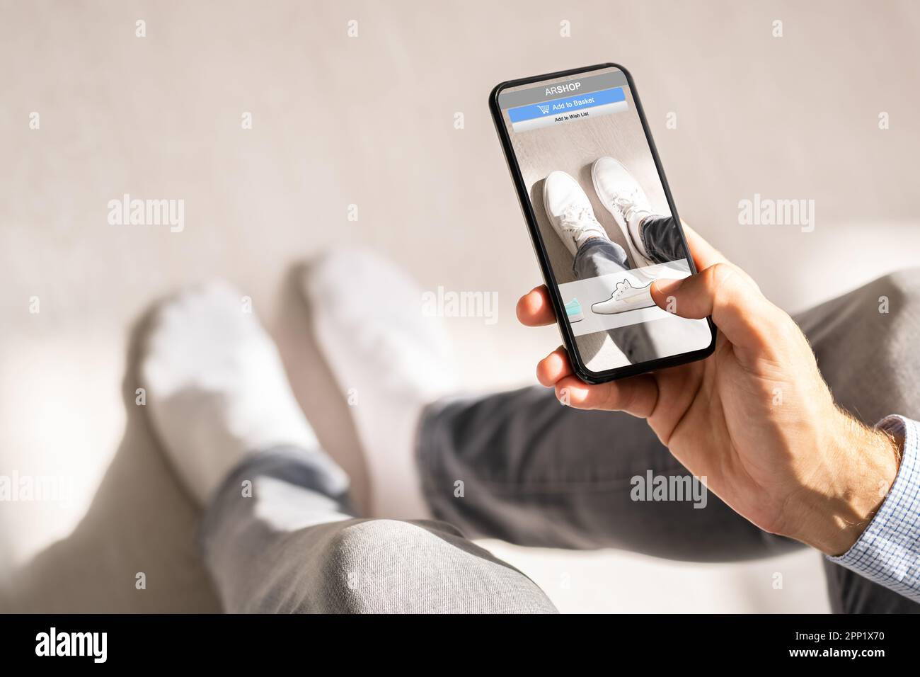 Homme essayant des baskets virtuelles dans Shop ou Store AR App Banque D'Images Homme essayant des baskets virtuelles dans Shop ou Store AR App Banque D'Images