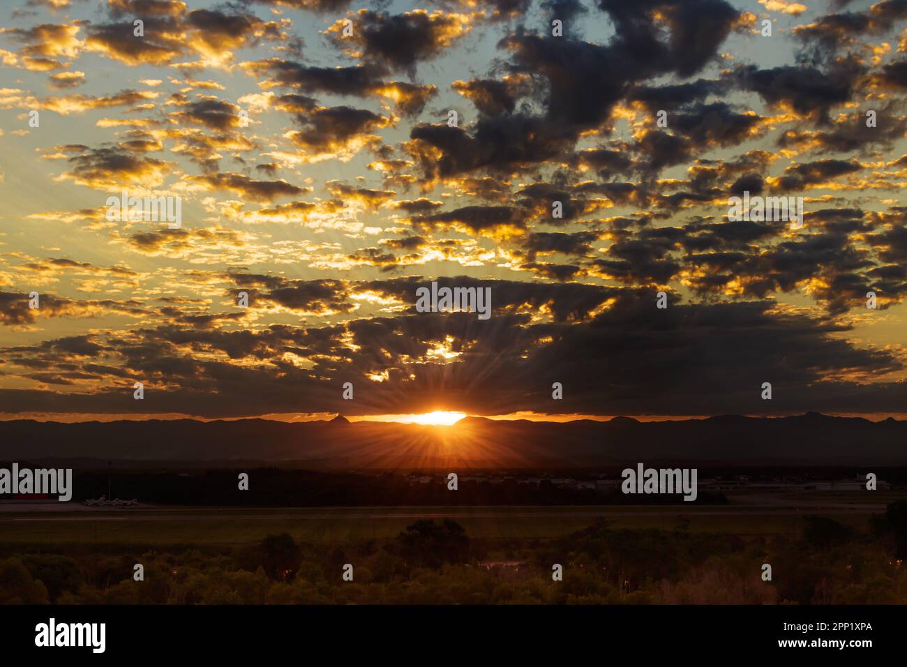 Un moment avant le magnifique coucher de soleil à Vitoria, vu de l'aéroport de Vitoria avec des forêts en premier plan et des montagnes en arrière-plan. Rayons de soleil Banque D'Images