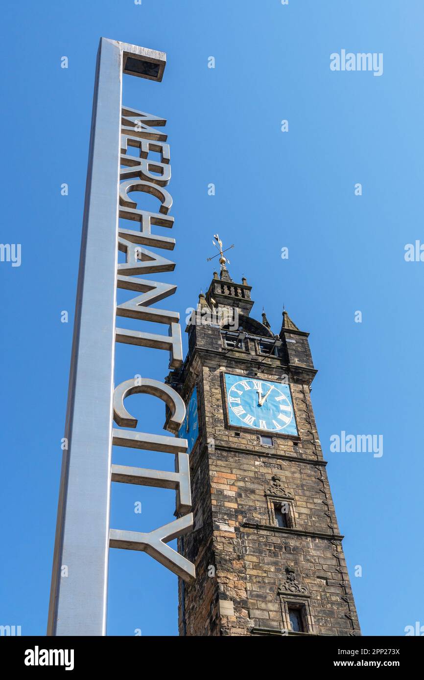 Panneau pour le quartier de Merchant City de Glasgow, à côté de l'horloge historique et médiévale de Glasgow Cross, Glasgow, Écosse, Royaume-Uni Banque D'Images