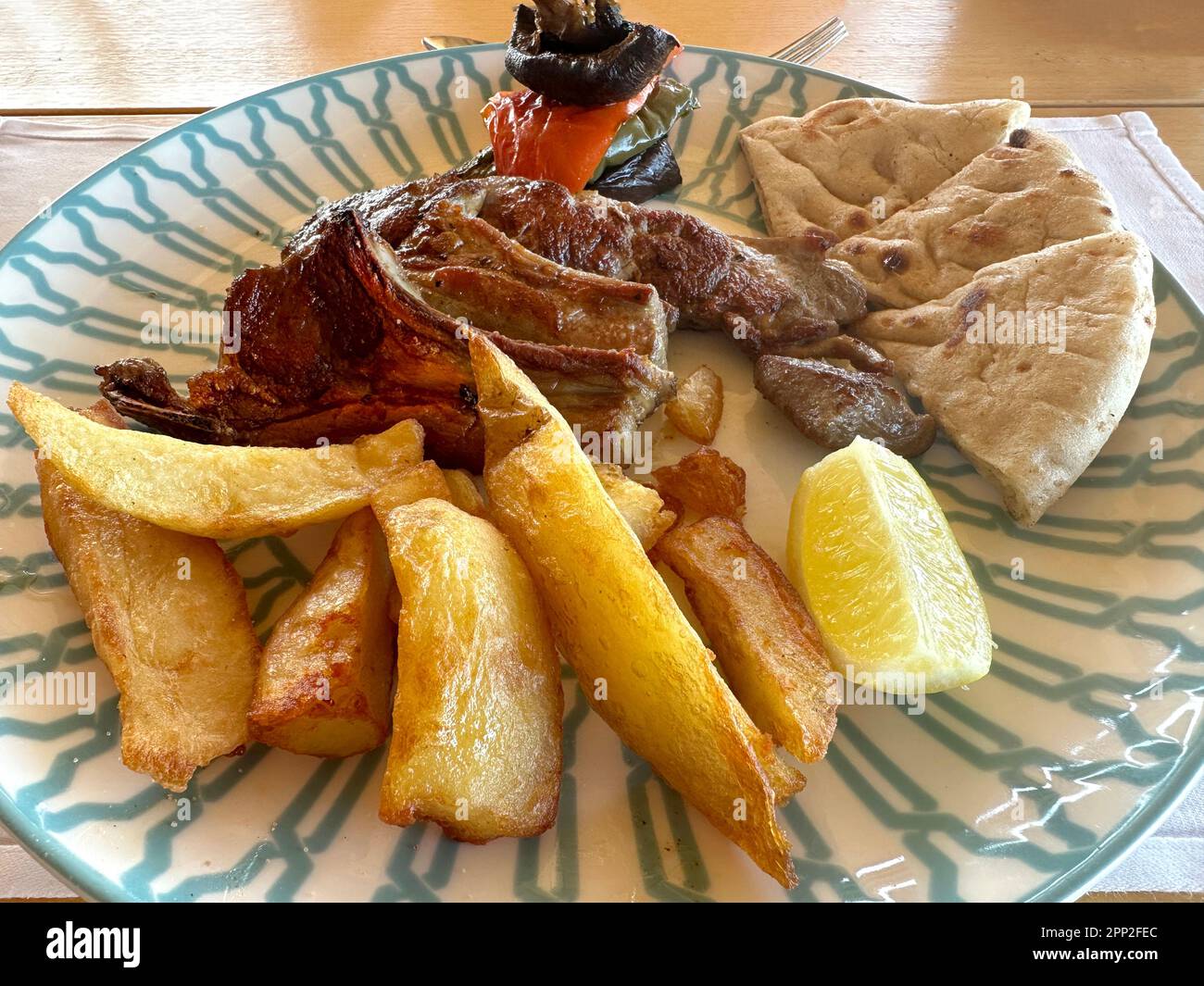 Dîner de hache d'agneau grillé avec légumes grillés, pain pita et frites Banque D'Images