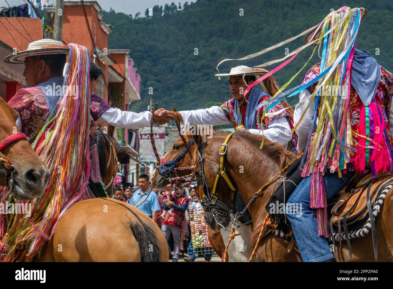 José Pérez se serre la main avec un autre pilote lors du festival de San Lorenzo, le Saint patron de Zinacantán, à Chiapas, au Mexique, le 10 août 2022. Au cours du festival, les plus expérimentés de la course des équidés dans la rue principale de la ville. (Marissa Revilla/Global Press Journal) Banque D'Images