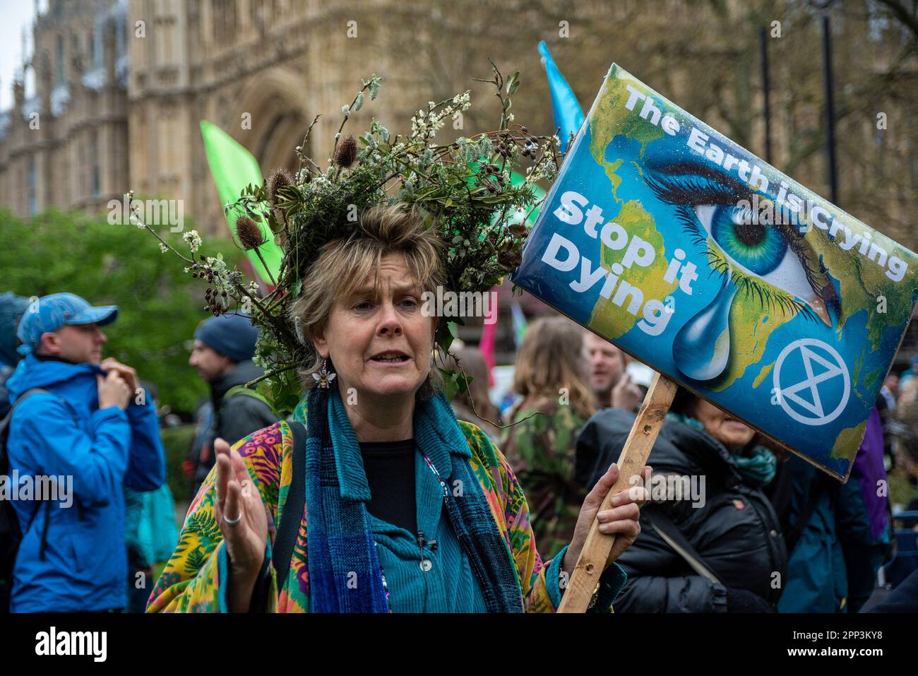 Londres, Royaume-Uni. 21st avril 2023. Un manifestant portant une couronne de fleur sauvage tient un écriteau qui dit « la Terre pleure. Stop IT Dying » pendant la manifestation de mars. 180 groupes d'organisations se sont unis pour faire une action du 21st avril au 24th avril à proximité du Parlement à Londres, Royaume-Uni. Ils l'appellent « la grande ». Les organisations ont l'intention de convaincre le gouvernement britannique de cesser d'inventer et d'utiliser les combustibles fossiles à l'avenir. Il y a eu des discours et une marche au cours de la première journée de l'action. (Photo de Krisztian Elek/SOPA Images/Sipa USA) Credit: SIPA USA/Alay Live News Banque D'Images