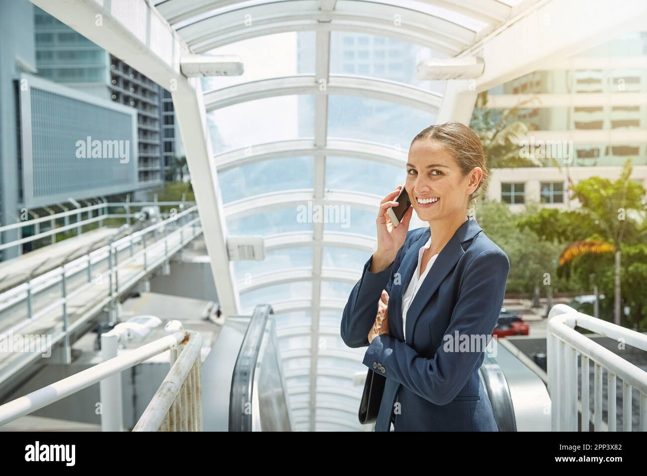 Prendre le temps de parler sur son chemin à travers la ville. une jeune femme d'affaires parle sur son téléphone portable en route vers le bureau. Banque D'Images