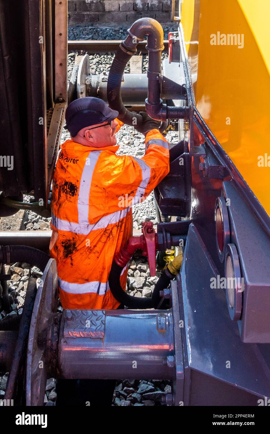 Irish Rail/Iarnród Éireann, un travailleur qui relie la locomotive 117087 à un train de la gare Connolly de Dublin, Dublin, Irlande. Banque D'Images