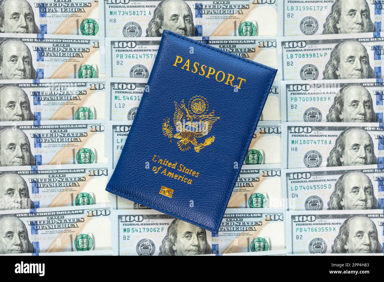 Passeports AMÉRICAINS dans un tas de billets en dollars américains. DOCUMENT US. Un passeport américain sur fond d'une grosse pile de dollars américains. La conce Banque D'Images