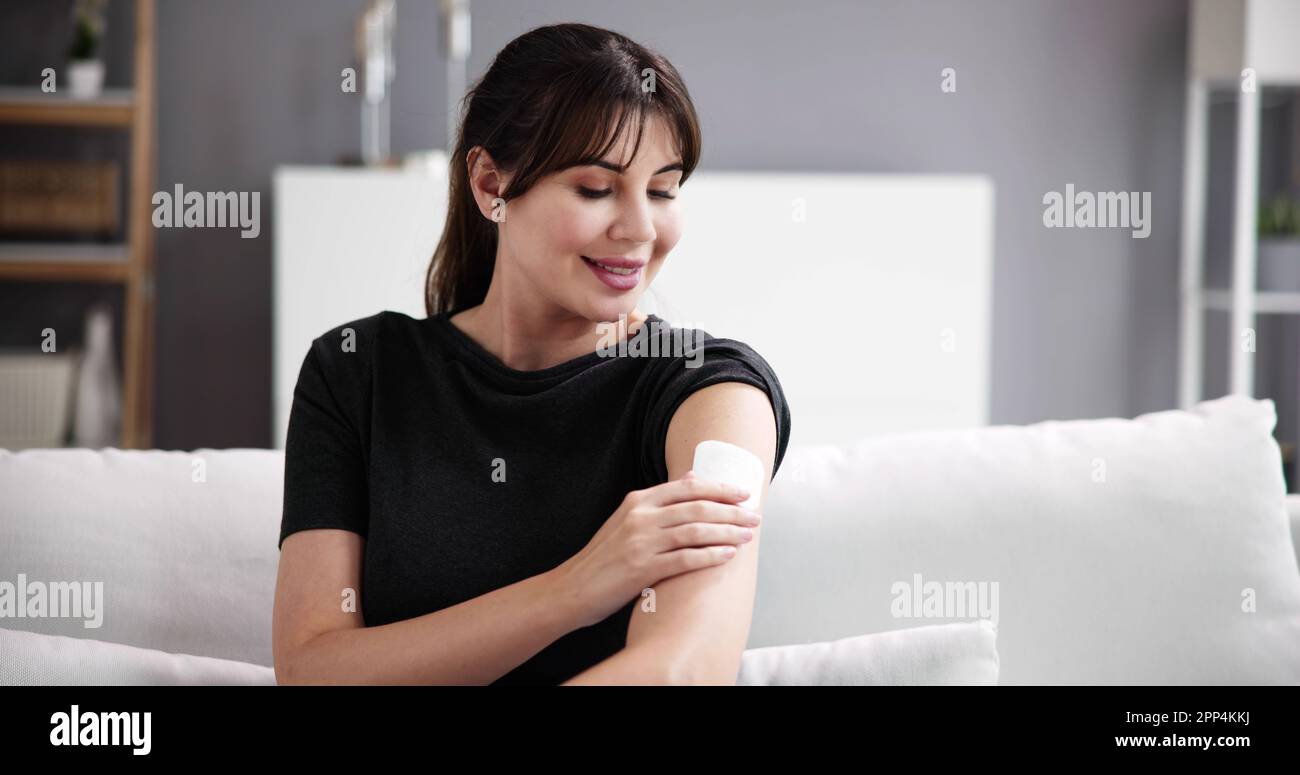 Femme avec un traitement patch de contraception sur le bras Banque D'Images