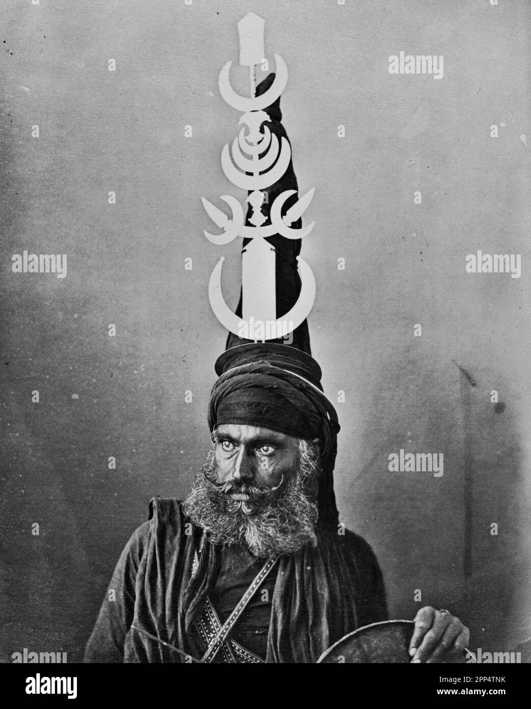 Portrait d'un guerrier sikh, également connu sous le nom de Nihang ou Akali, portant un turban conique élaboré, orné de chakrams ou de quoses de guerre. Banque D'Images