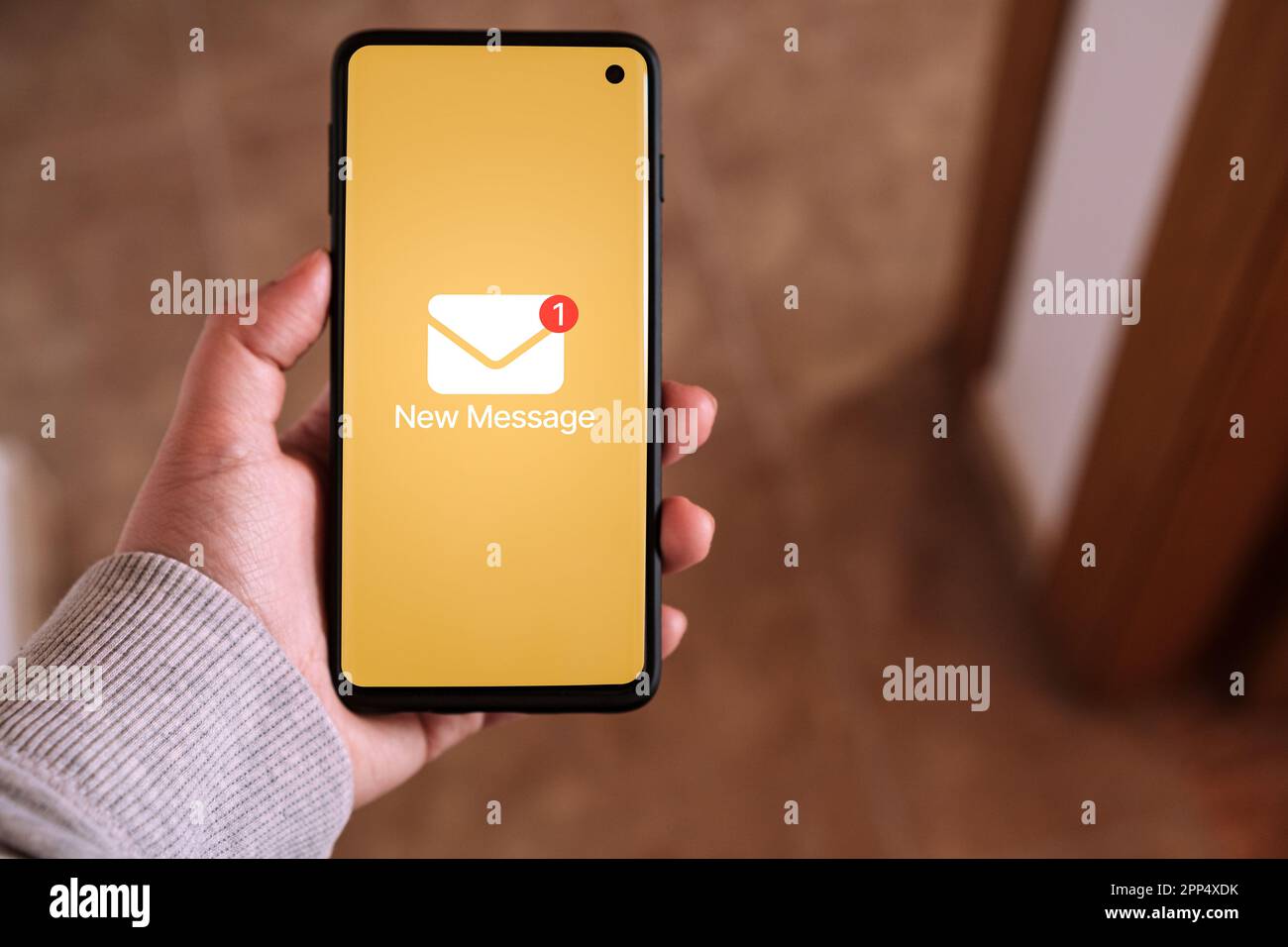 La main d'une femme tient un smartphone avec une notification de nouveau message à l'écran. Technologie de communication. Vue boîte de réception. Nouvel e-mail sur mobile. Banque D'Images