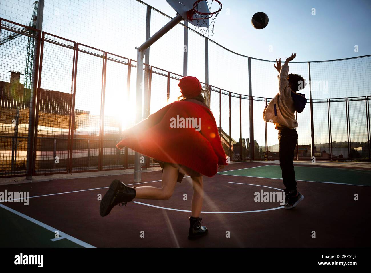 Enfants jouant au basket-ball ensemble à l'extérieur Banque D'Images