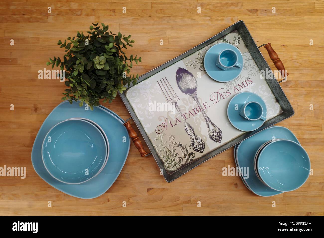 vaisselle bleu turquoise avec une plante verte et un plateau sur une table  en bois. Traduction sur le plateau: À la table avec des amis Photo Stock -  Alamy