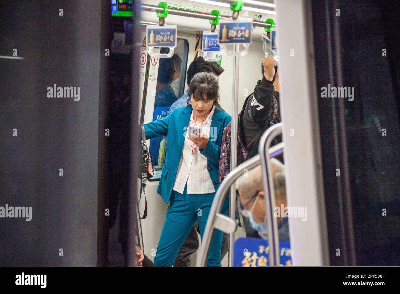 NANJING, CHINE - le 22 AVRIL 2023 - les passagers lisent leur téléphone mobile dans une voiture de métro à Nanjing, dans la province du Jiangsu, en Chine orientale, à 22 avril, en 202 Banque D'Images