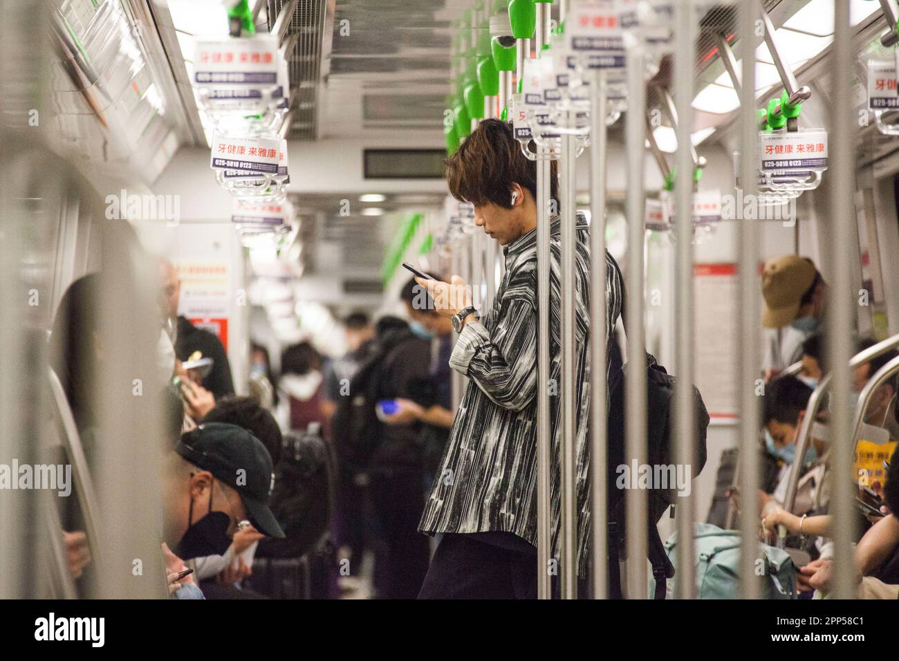 NANJING, CHINE - le 22 AVRIL 2023 - les passagers lisent leur téléphone mobile dans une voiture de métro à Nanjing, dans la province du Jiangsu, en Chine orientale, à 22 avril, en 202 Banque D'Images