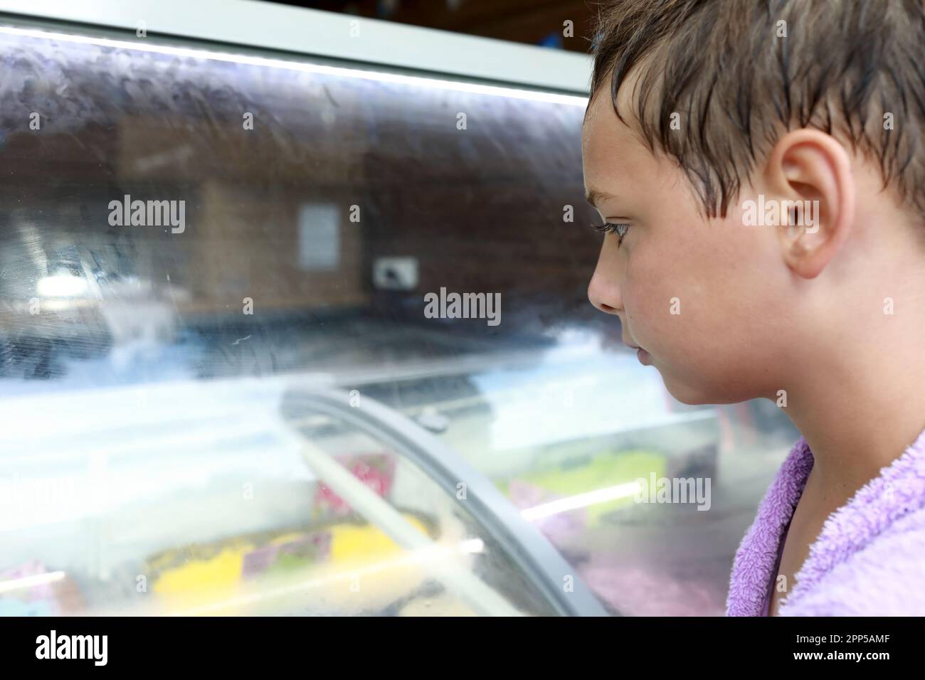 Portrait de l'enfant qui choisit de la crème glacée sur la vitrine du café Banque D'Images