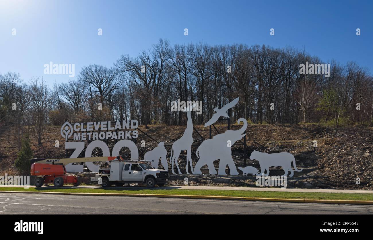 Un panneau récemment installé pour le Cleveland Metroparks Zoo est ancré à une pente face à une grande autoroute. L'équipement pour le travail est toujours en place. Banque D'Images
